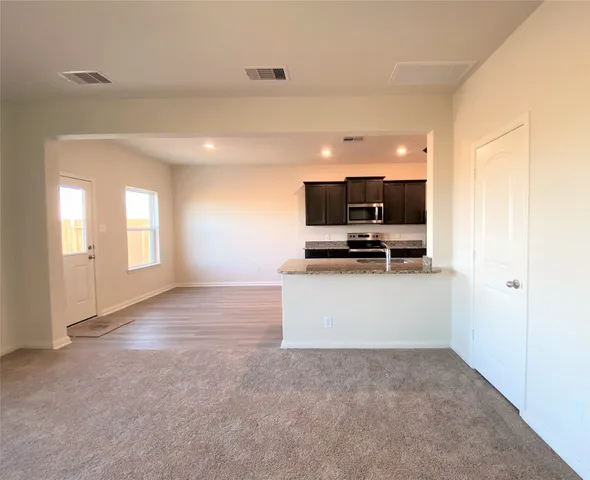 a view of a kitchen with flat screen tv and refrigerator