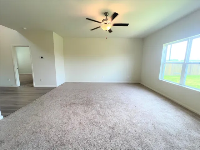 an empty room with fan and windows