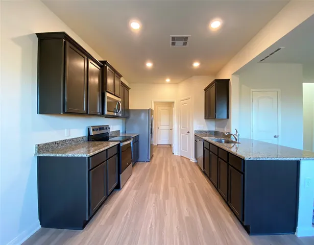 a large kitchen with stainless steel appliances granite countertop plenty wooden cabinets and granite counter tops