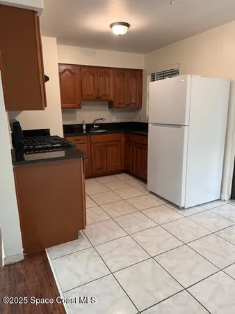 a kitchen with granite countertop a refrigerator and a stove top oven