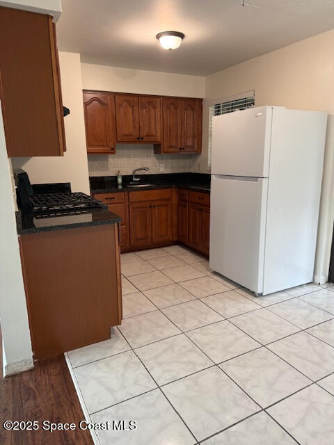 1043 Jersey Street Cocoa, FL 32927 - Photo 6 of 16 a kitchen with granite countertop a refrigerator and a stove top oven