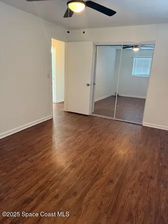 an empty room with wooden floor and white walls
