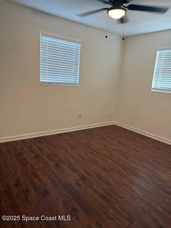 an empty room with wooden floor and a sink