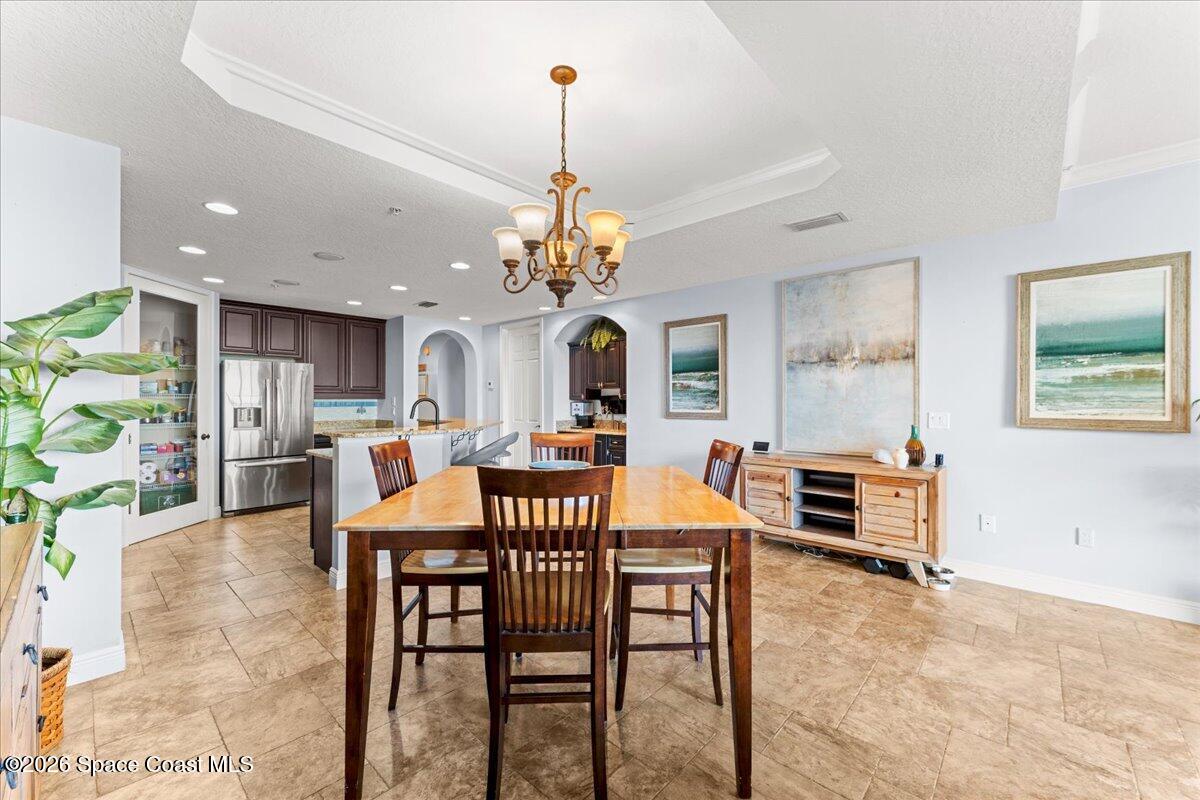 4125 West End Road, Unit 405 Cocoa Beach, FL 32931 - Photo 11 of 44 a view of a dining room with furniture and chandelier