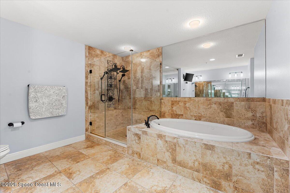 4125 West End Road, Unit 405 Cocoa Beach, FL 32931 - Photo 18 of 44 a bathroom with a tub a window and a shower