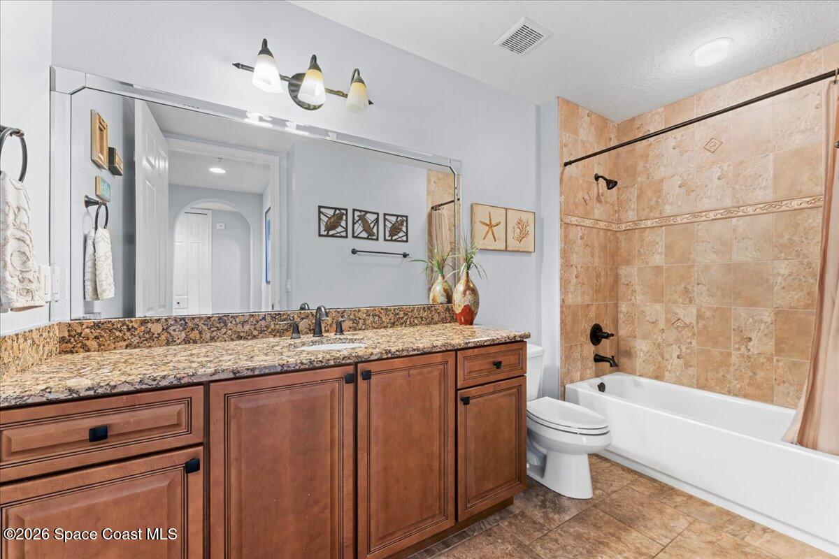 4125 West End Road, Unit 405 Cocoa Beach, FL 32931 - Photo 22 of 44 a bathroom with a granite countertop sink a toilet and bathtub