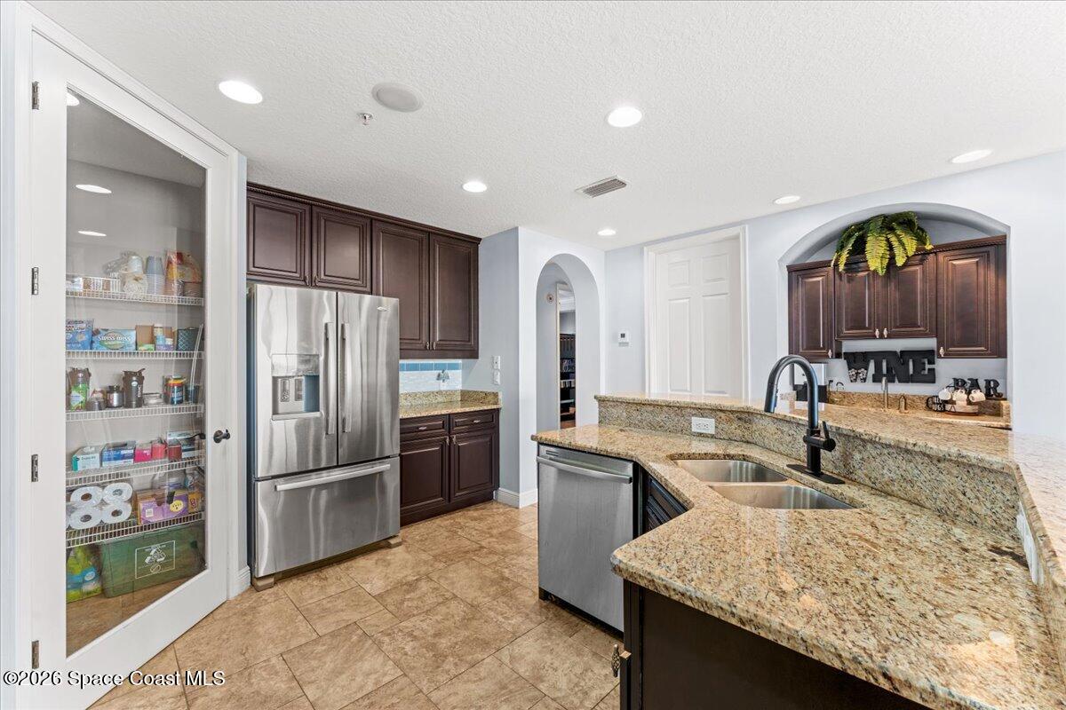 4125 West End Road, Unit 405 Cocoa Beach, FL 32931 - Photo 6 of 44 a kitchen with stainless steel appliances granite countertop a sink and a refrigerator