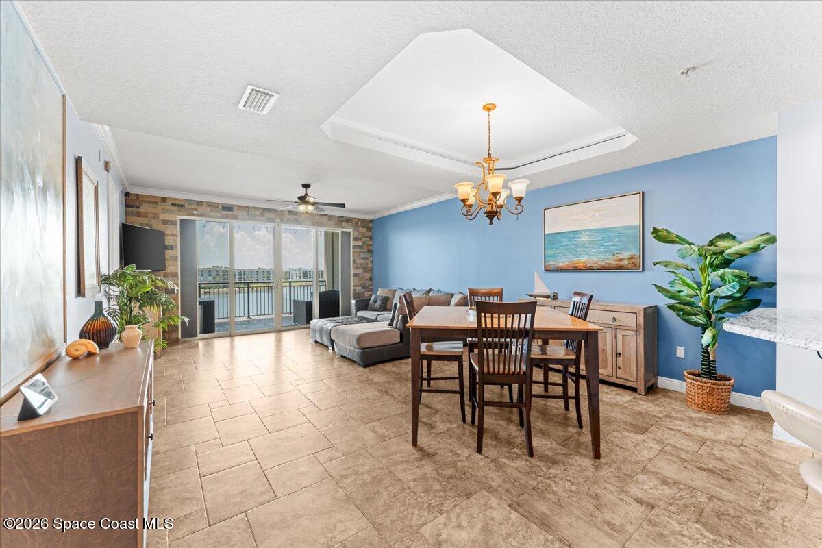 4125 West End Road, Unit 405 Cocoa Beach, FL 32931 - Photo 44 of 44 a view of a dining room and livingroom with furniture wooden floor a chandelier