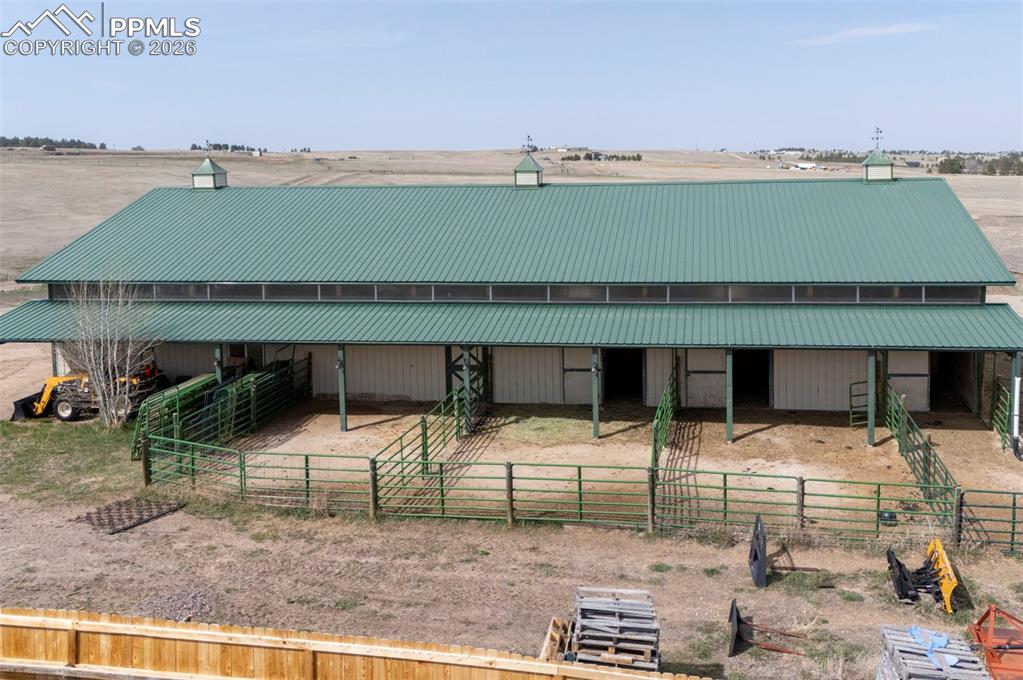 5910 McCart Ranch Circle Elizabeth, CO 80107 - Photo 38 of 50 50x100 metal drive-through barn has a concrete floor, w/ a half bath, 4 stalls w/turnouts (3 w/ automatic waterers), 2hydrants, a horse wash bay, work benches, and a heated tack room