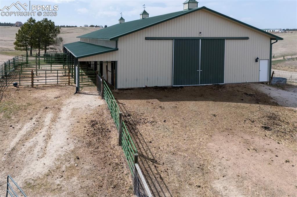 5910 McCart Ranch Circle Elizabeth, CO 80107 - Photo 39 of 50 50x100 metal drive-through barn has a concrete floor, w/ a half bath, 4 stalls w/turnouts (3 w/ automatic waterers), 2hydrants, a horse wash bay, work benches, and a heated tack room