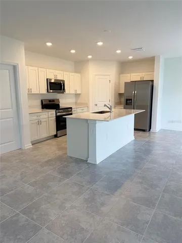 a kitchen with stainless steel appliances a refrigerator and a stove top oven
