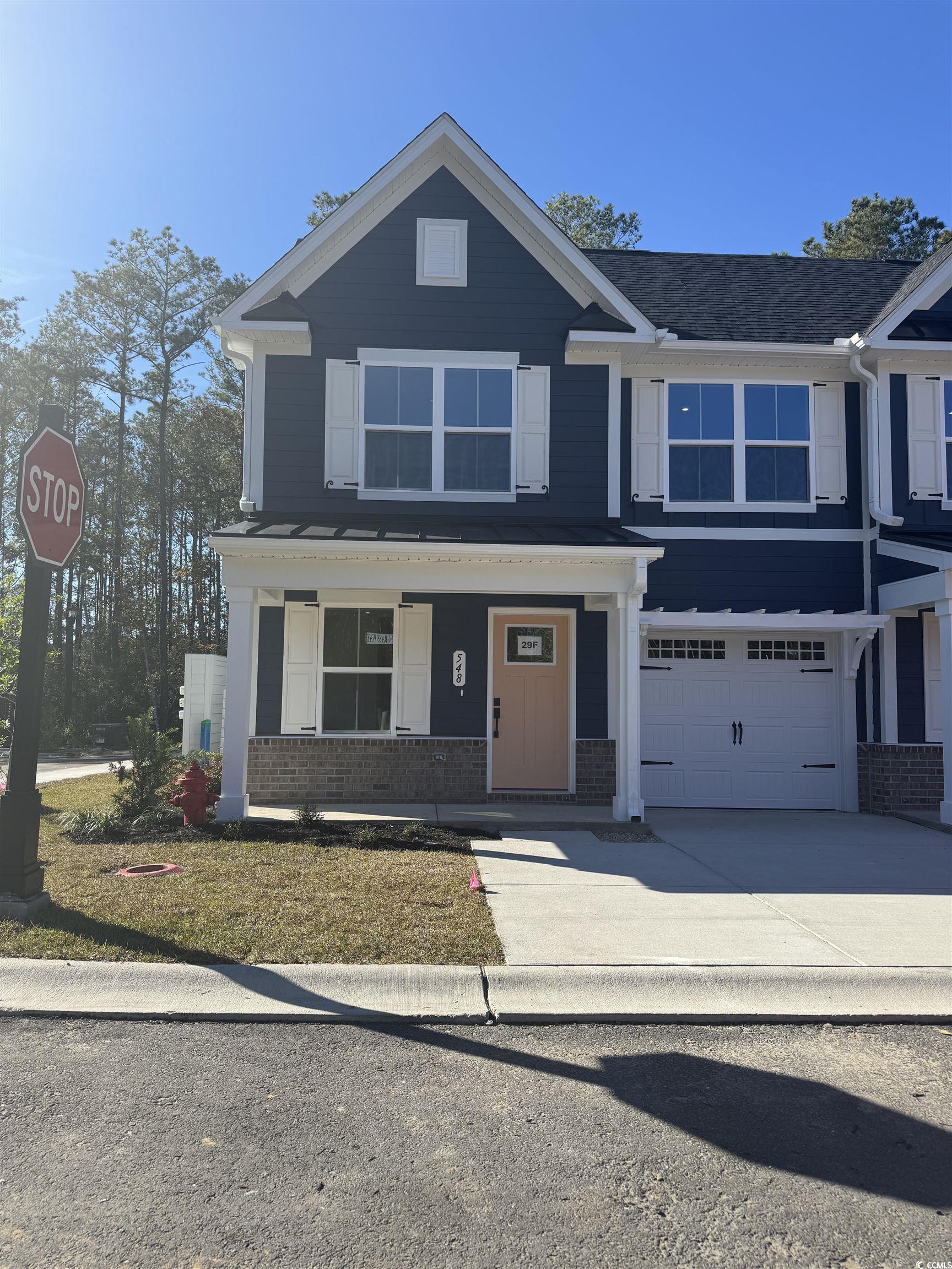548 Ryegrass Way, Unit 29F Murrells Inlet, SC 29576 - Photo 1 of 14 Craftsman house with covered porch, brick siding, driveway, and a garage