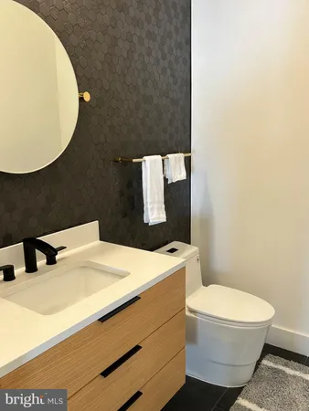 a bathroom with a sink a toilet and mirror
