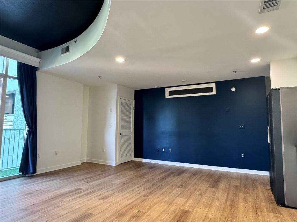 250 Pharr Road Northeast, Unit 601 Atlanta, GA 30305 - Photo 9 of 34 an empty room with wooden floor and windows