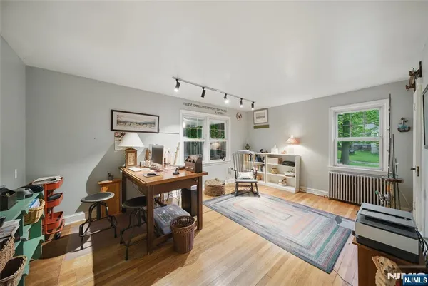 a view of a workspace with furniture window and wooden floor