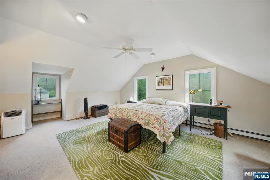 351 Franklin Road Denville, NJ 07834 - Photo 25 of 45 a spacious bedroom with a bed a table and chair