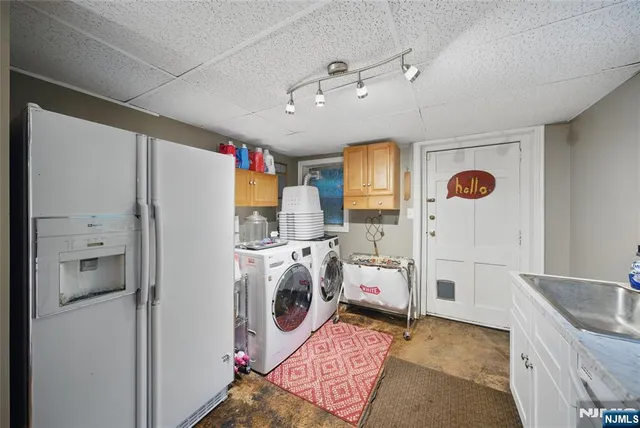 a view of kitchen with stainless steel appliances granite countertop a refrigerator and a sink