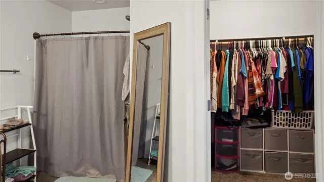 a view of walk in closet with clothes
