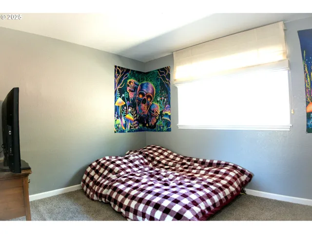 a bedroom with a bed and a wall painting