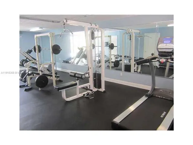 a room with gym equipment and large mirror