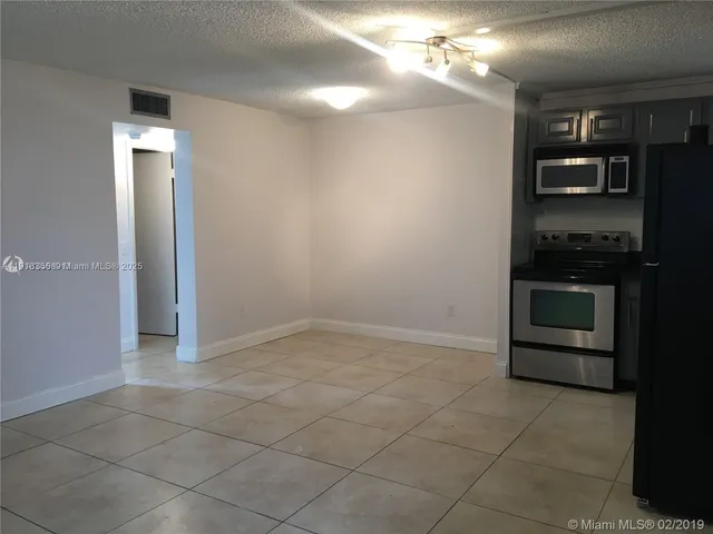 a view of a kitchen with a stove cabinets and a kitchen space
