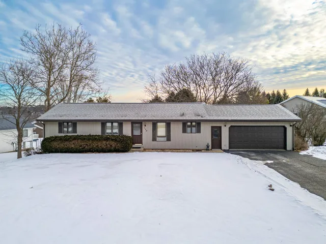 a front view of a house with yard and trees