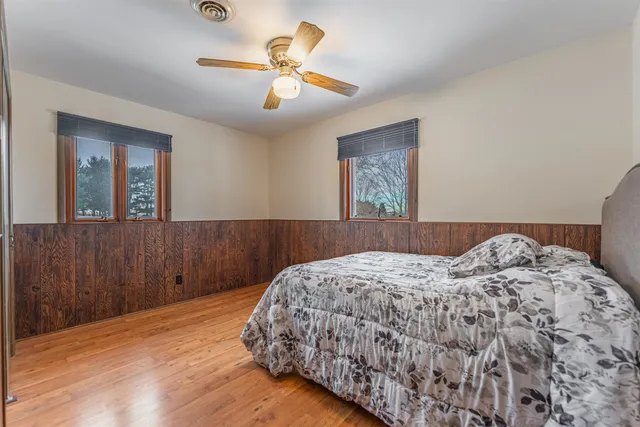 an empty room with wooden floor closet and windows