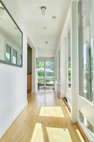 a view of a hallway with wooden floor and windows