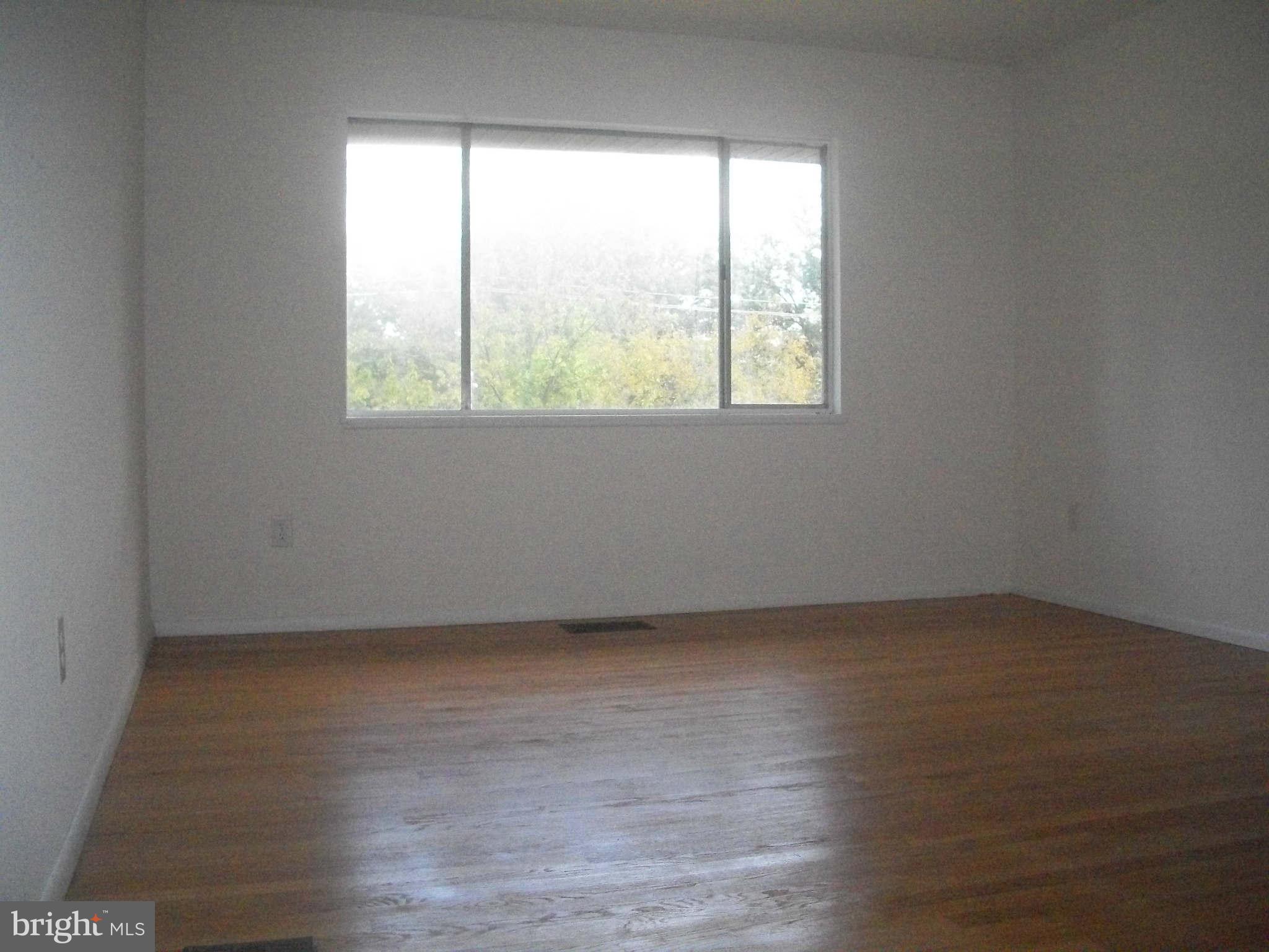 5634 Westgate Road Lanham, MD 20706 - Photo 2 of 12 an empty room with wooden floor and windows