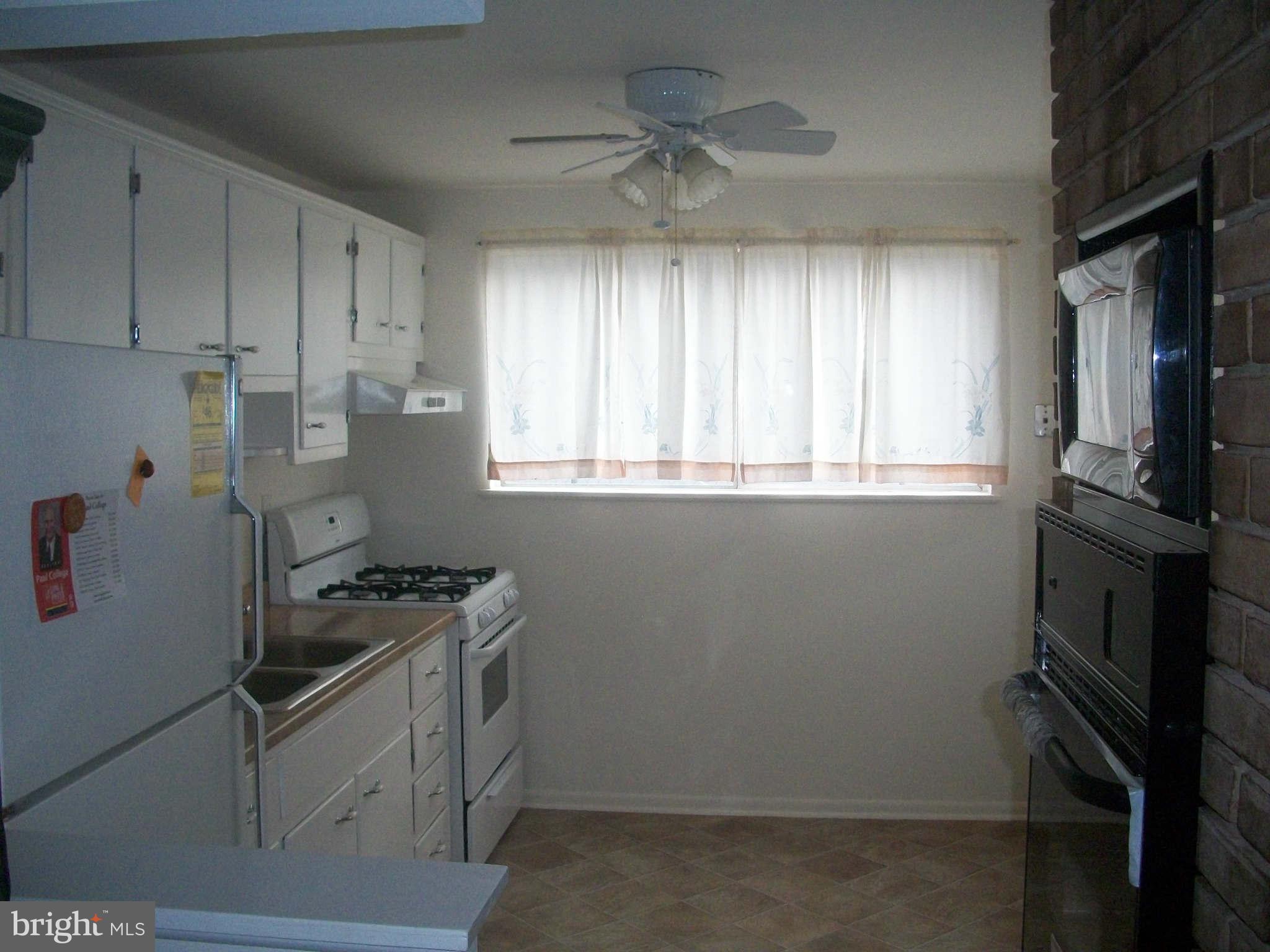 5634 Westgate Road Lanham, MD 20706 - Photo 4 of 12 a kitchen with a stove microwave and a window