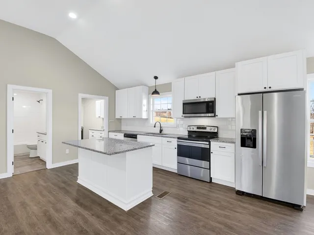 a kitchen with white cabinets and stainless steel appliances