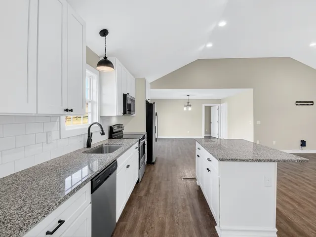 a kitchen with granite countertop kitchen island a sink appliances and cabinets
