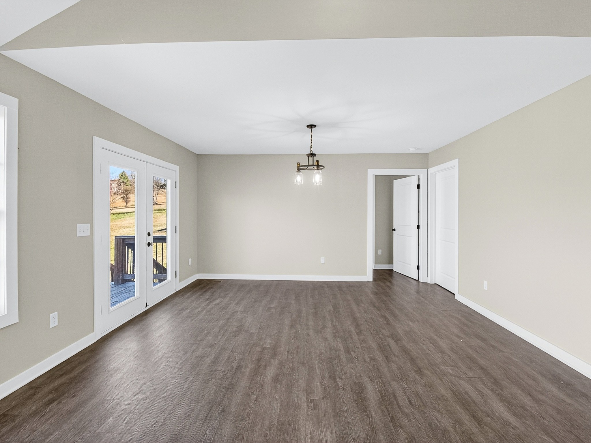 621 Womack Road Bethpage, TN 37022 - Photo 23 of 50 an empty room with wooden floor chandelier and windows