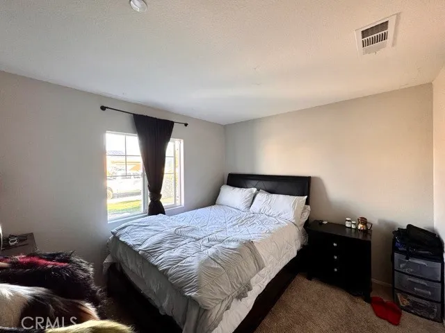 a bedroom with a bed and dresser with mirror