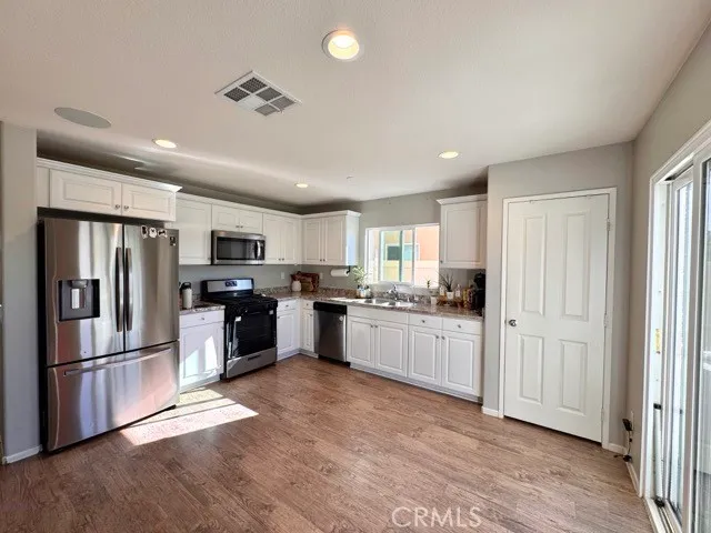 a kitchen with stainless steel appliances kitchen island granite countertop a refrigerator and a stove top oven