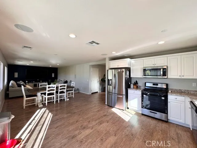 a kitchen with stainless steel appliances dining table and wooden floor