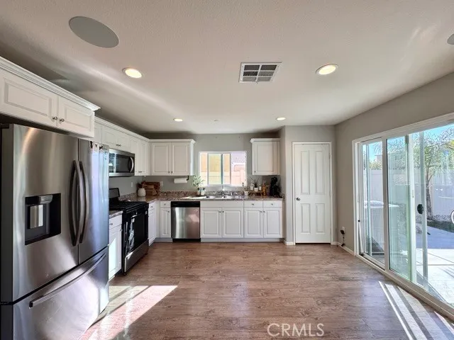 a large kitchen with a large window and stainless steel appliances