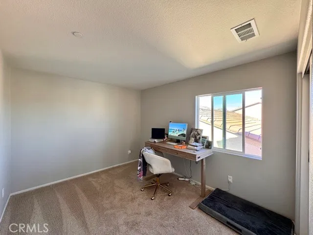 a view of a workspace with furniture and a window