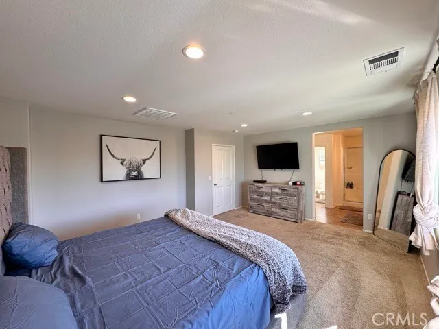 a bedroom with bed and a flat screen tv