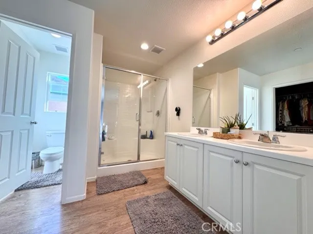 a bathroom with a double vanity sink mirror and shower