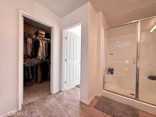 a view of a hallway with wooden floor and closet
