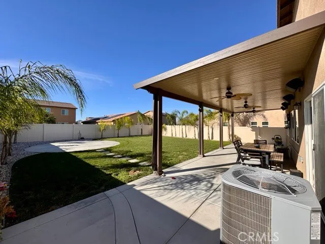 a view of a patio with table and chairs near a barbeque