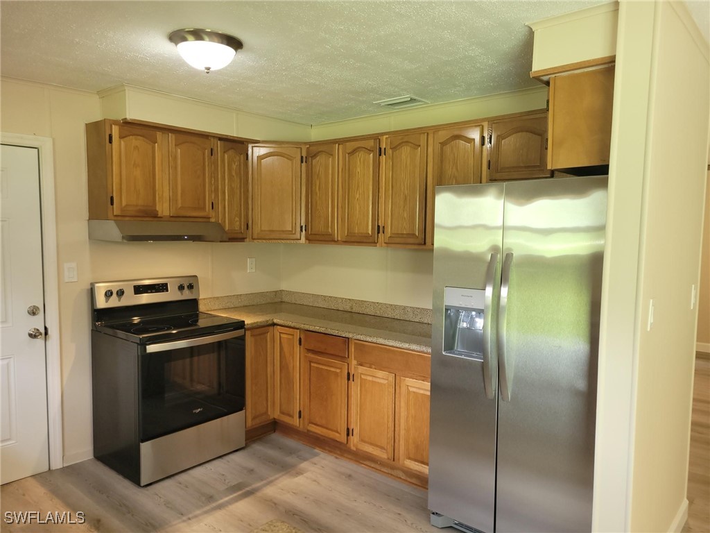 2371 County Road 78 LaBelle, FL 33935 - Photo 4 of 17 a kitchen with a sink stainless steel appliances wooden floor and cabinets