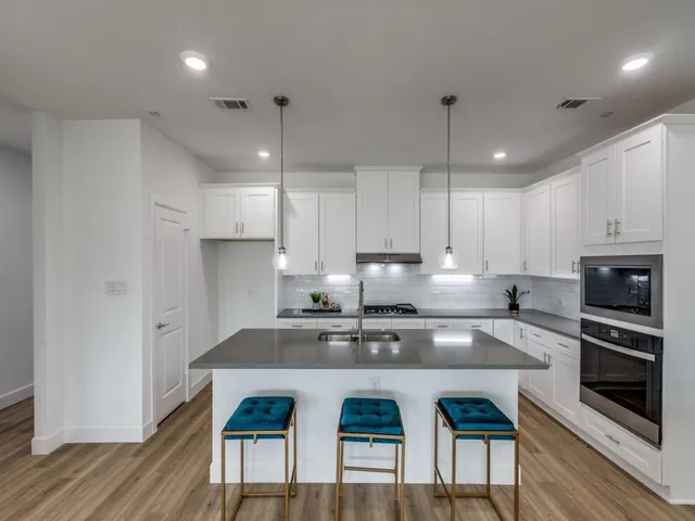 a kitchen with stainless steel appliances granite countertop a stove a sink a microwave a center island and cabinets