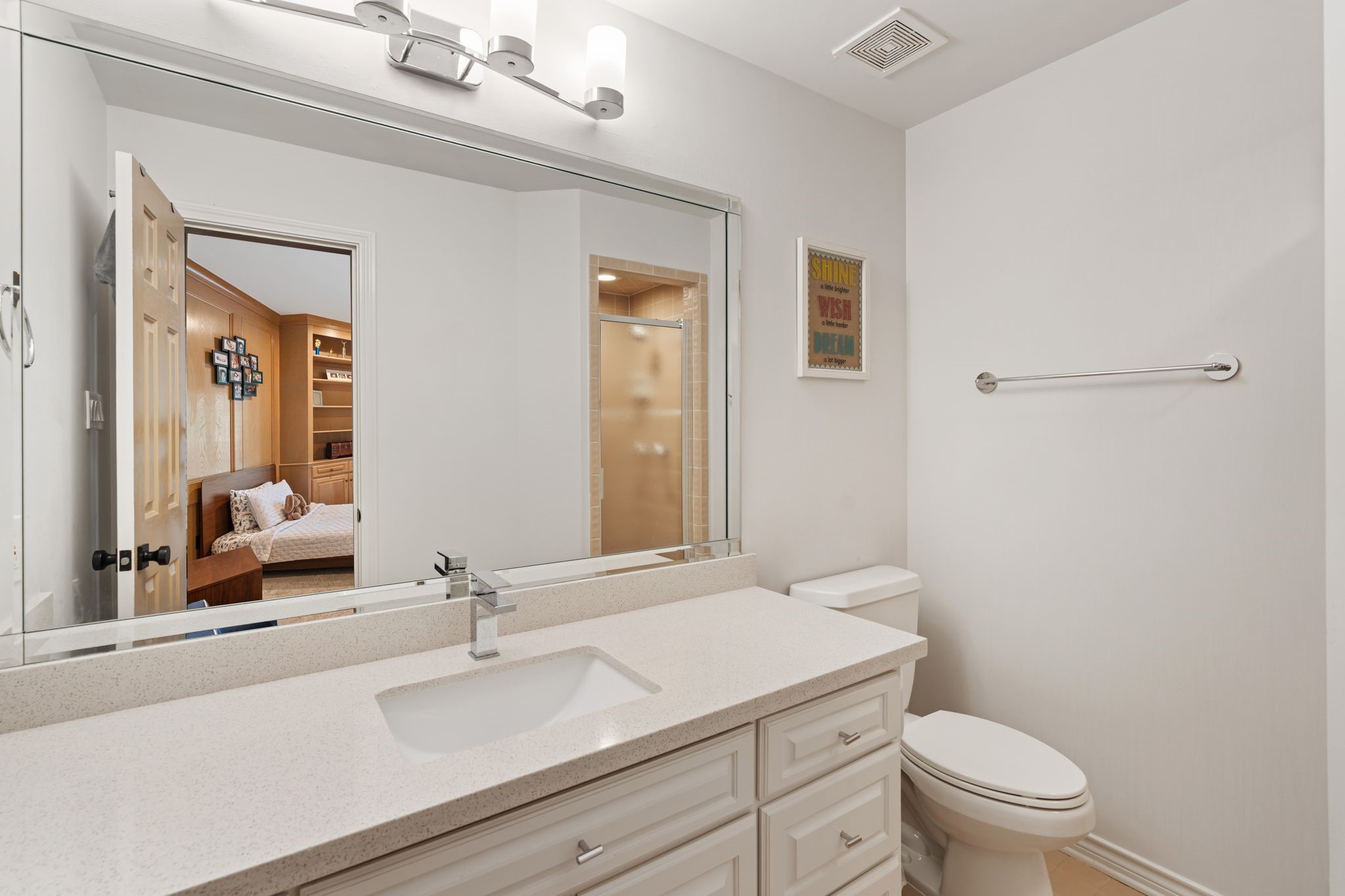 201 Vanderpool Lane, Unit 137 Houston, TX 77024 - Photo 29 of 42 The adjoining bathroom features a large vanity with generous counter space, white cabinetry, and a mix of drawer and cabinet storage for everyday functionality. A framed mirror, vanity lighting, tile flooring, and sleek silver hardware keep the space feeling bright and polished, while the walk-in shower adds a clean, updated touch.
