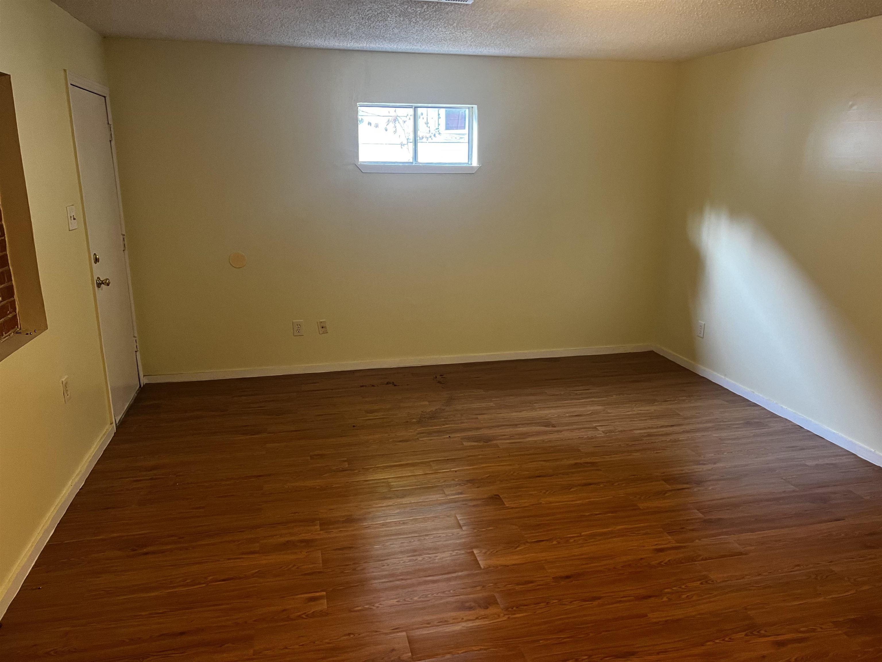 1336 James Street Memphis, TN 38106 - Photo 3 of 5 a view of an empty room with wooden floor and a window