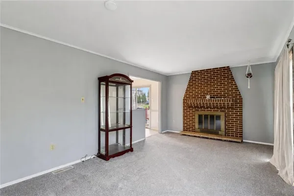 a view of an empty room with a fireplace and a window