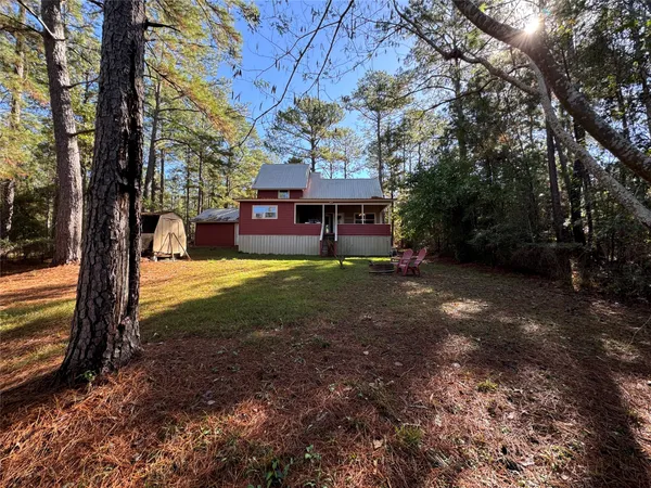a view of a house with backyard and tree