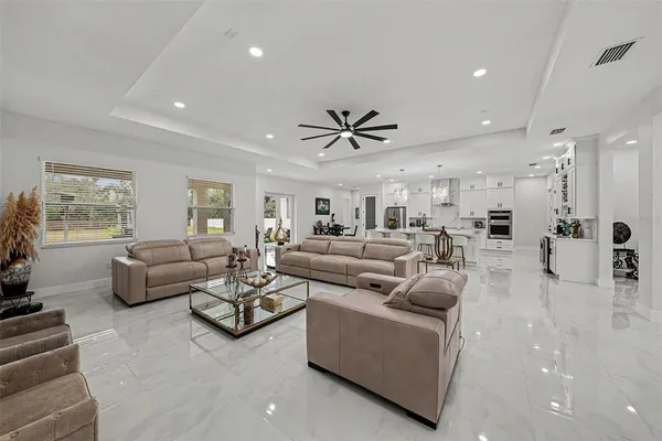 a living room with furniture ceiling fan and a window