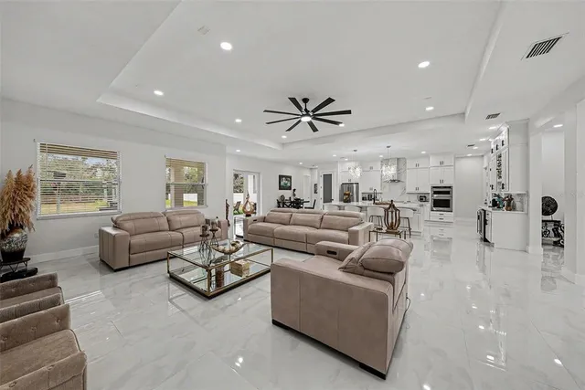 a living room with furniture ceiling fan and a window